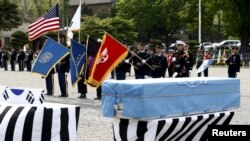 FILE - Members of the United Nations Command honor guards salute in front of boxes containing the remains of the United Nations Command (UNC) and South Korean soldiers who were killed inside North Korea in the 1950-53 Korean War during a repatriation ceremony at Knight Field at Yongsan garrison in Seoul, South Korea, April 28, 2016.
