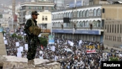 A Houthi militant stands guard as Houthi followers demonstrate against Saudi-led airstrikes in Yemen's capital Sana'a, July 24, 2015. 