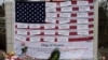 Names of victims are displayed on a flag in the business area in Newtown, Connecticut, December 16, 2012. 