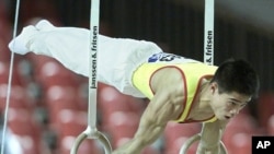 Chinese Shangwu Zhang performs on the rings during the men's qualifying round at the World Artistic Gymnastic Championships in Ghent October 29, 2001.