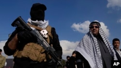 FILE - Members of an Iraqi Shiite militant group attend the funeral of a fighter with the Kataib Hezbollah, who was killed in a U.S. airstrike, in Baghdad, Iraq, Jan. 25, 2024.