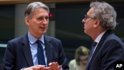 Menkeu Inggris, Philip Hammond, kiri, berbicara dengan Menkeu Luxembourg Pierre Gramegna selama pertemuan meja bundar para menkeu Uni Eropa (27/1). Brussels, Belgia. (foto: AP Photo/Geert Vanden Wijngaert)