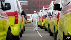 Un trabajador sanitario con ropa de protección camina entre ambulancias para trasladar a pacientes en Daegu, Corea del Sur, el domingo 1 de marzo de 2020. (Ryu Young-seok/Yonhap via AP)