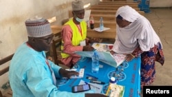 Une électrice signe après avoir voté lors des premières élections régionales à Maroua, Cameroun, le 6 décembre 2020.