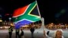 A girl holds a South African national flag as people mourn the death of former President Nelson Mandela outside Cape Town City Hall, where Mandela made his first speech after his release from his 27-year incarceration, Dec. 6, 2013. 