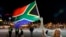 A girl holds a South African national flag as people mourn the death of former President Nelson Mandela outside Cape Town City Hall, where Mandela made his first speech after his release from his 27-year incarceration, Dec. 6, 2013. 