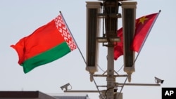 FILE - The Belarusian flag is flown near the Chinese flag on Tiananmen Square in Beijing, March 1, 2023. China and Belarus began joint anti-terrorism exercises in Brest, Belarus, on July 8, 2024.