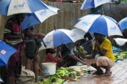 Rohingya refugees hide under umprellas during rainfall at Kutupalong refugee camp in Ukhia, Cox's Bazar, Bangladesh, Sept. 12, 2019.