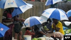 Rohingya refugees hide under umprellas during rainfall at Kutupalong refugee camp in Ukhia, Cox's Bazar, Bangladesh, Sept. 12, 2019. 
