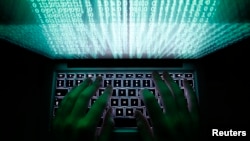 FILE - A man types on a computer keyboard in Warsaw. 