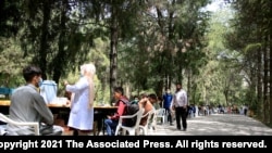 FILE - Afghan students wait to receives a dose of the Johnson & Johnson COVID-19 vaccine in Kabul University, Afghanistan.