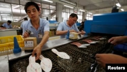 Công nhân Trung Quốc làm việc tại nhà máy giày ở Cám Châu, tỉnh Giang Tây.