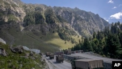 FILE - An Indian army convoy moves along the Srinagar-Ladakh highway at Gagangeer, northeast of Srinagar, Indian-administered Kashmir, Sept. 9, 2020. Control over the Ladakh border region is a key friction point between India and China.