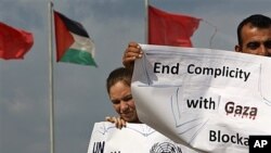 Activists in front of Palestinian, Turkish flags show support for 27 civilians from various countries attempting to reach the Gaza Strip by boat, sea port of Gaza City, Nov. 4, 2011.