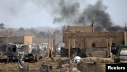 Islamic State members walk in the last besieged neighborhood in the village of Baghouz, Deir al-Zor province, Syria, March 10, 2019. 