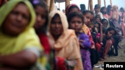 Rohingya refugees line up to receive humanitarian aid in Balukhali refugee camp near Cox's Bazar, Bangladesh, Oct. 26, 2017. 