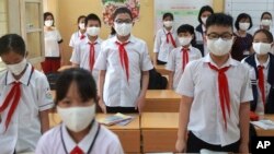 Students stand up for Vietnamese national anthem as they start a new week in Dinh Cong secondary school in Hanoi, Vietnam Monday, May 4, 2020. Students across Vietnam return to school after three months of studying online due to school closure to contain COVID-19. (AP/Hau Dinh)