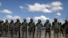 People waiting to cross to Venezuela stand opposite Venezuelan National guards at the border between Venezuela and Brazil in Pacaraima, Roraima state, Brazil, Feb. 22, 2019. 