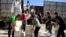 FILE - Syrian men carry aid parcels provided by the U.N. World Food Program and the Syrian Arab Red Crescent in the rebel-held town of Al-Houla, on the northern outskirts of Homs in central Syria, May 25, 2016.