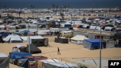 A man walks amid tents in a camp in Rafah in the southern Gaza Strip by the border with Egypt on April 28, 2024.