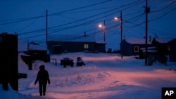 FILE - A woman walks in Toksook Bay, Alaska, a mostly Yup'ik village on the edge of the Bering Sea, Jan. 20, 2020. A judge ruled in favor of tribal nations in a bid to keep Alaska Native corporations from getting part of $8 billion in COVID relief funding