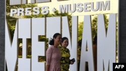 Women walk past the Vietnam Press Museum in Hanoi on July 16, 2020. - Vietnam's newly-opened Press Museum shows history of journalism in the communist country. (Photo by Nhac NGUYEN / AFP)