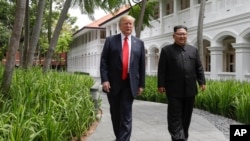 U.S. President Donald Trump and North Korea leader Kim Jong Un walk at the Capella resort on Sentosa Island in Singapore, June 12, 2018.