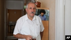 In this photo taken on July 23, 2015, Mehman Aliyev, the Turan news agency's director poses for a photo in the agency's office in Baku, Azerbaijan. A court in Azerbaijan on Aug. 25, 2017, ordered the arrest of Aliyev for three months pending an investigation on tax evasion charges, a move the opposition has denounced as an attack on freedom of speech.