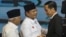 Indonesian presidential candidates Joko Widodo, right, Prabowo Subianto, center, and Subianto's running mate Hatta Rajasa greet each other during a televised debate in Jakarta, June 9, 2014