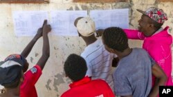 Zimbabweans check the results posted outside a polling station in Bulawayo, Zimbabwe, July 31, 2018. 