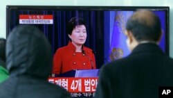 FILE - People watch a live broadcast of South Korean President Park Geun-hye's press conference, at the Seoul Railway Station in Seoul, South Korea, Jan. 13, 2016. Park called for resumption of nuclear talks, even if Pyongyang does not participate. 