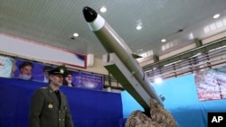 FILE - In this photo released by the official website of the Iranian Defense Ministry Aug. 13, 2018, Defense Minister Gen. Amir Hatami walks past a missile display at an undisclosed location in Iran. 