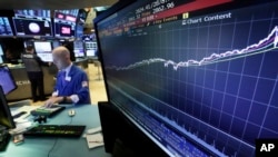 FILE- A chart on a screen on the floor of the New York Stock Exchange shows the rise of the S&P 500 index since 2009, Aug. 22, 2018.