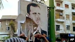 A video downloaded from YouTube shows Syrian anti-government protesters tearing down a portrait of President Basahr al-Assad in Hama on April 29, 2011 during the "Day of Rage" demonstrations