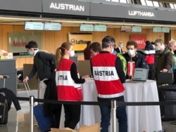 Austrians heading home get their papers checked on March 23, 2020 at Dulles Airport.