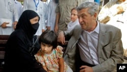 U.N. High Commissioner for Refugees Filippo Grandi talks to an Afghan refugee woman during his visit to the UNHCR's Repatriation Center in Peshawar, Pakistan, June 23, 2016.