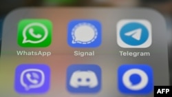 FILE - This picture taken Jan. 22, 2021 in Rennes, France, shows a smartphone screen featuring messaging service applications WhatsApp, Signal, Telegram.