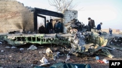 Orang-orang berdiri di dekat reruntuhan setelah sebuah pesawat Ukraina yang jatuh di dekat bandara Imam Khomeini di Teheran pada 8 Januari 2020, sebagai ilustrasi. (Foto: AFP)