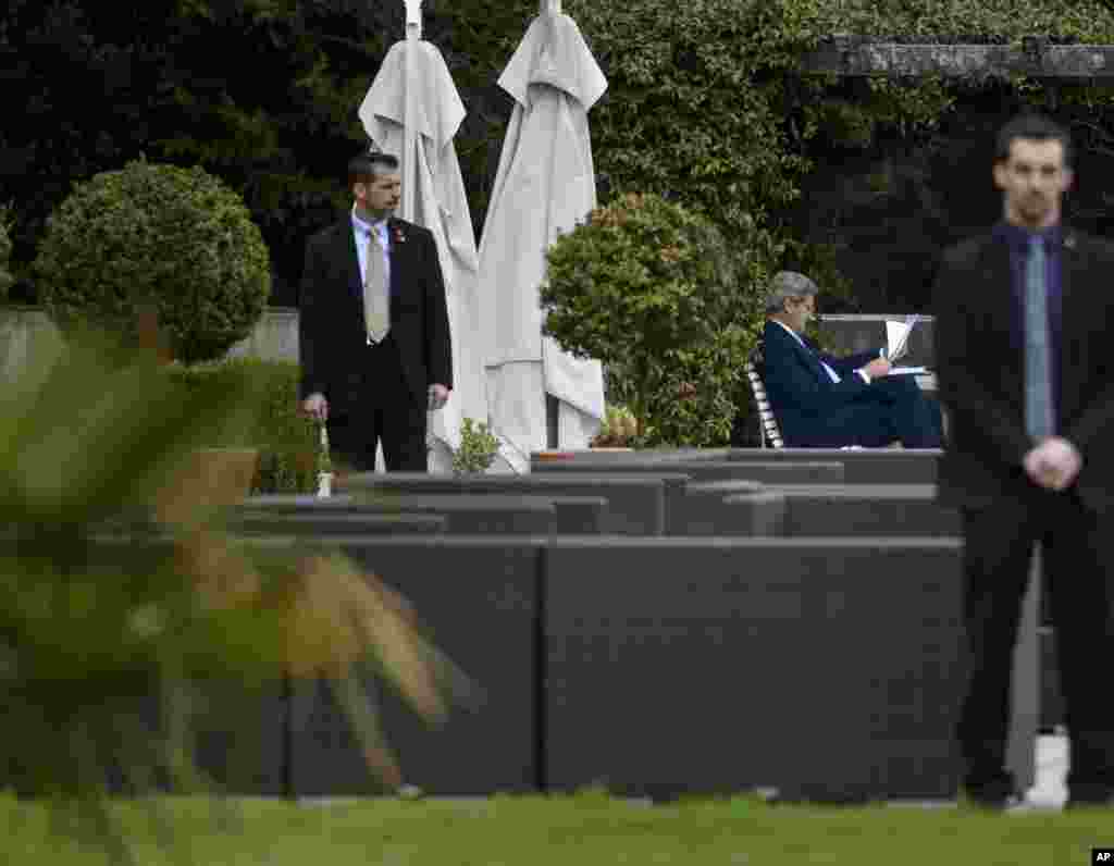 U.S. Secretary of State John Kerry looks over papers in the courtyard of the Beau Rivage Palace Hotel after an extended round of talks on Iran's nuclear program, in Lausanne, April 2, 2015.