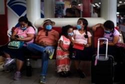 Tourists from Mexico wearing masks as a precaution against the spread of the new coronavirus, wait for their flight home, at the Jose Marti International Airport in Havana, Cuba, March 23, 2020.