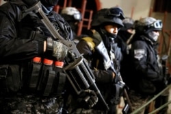 Police officers block a road leading to the Presidential Palace during a protest march in La Paz, Bolivia, Oct. 26, 2019.