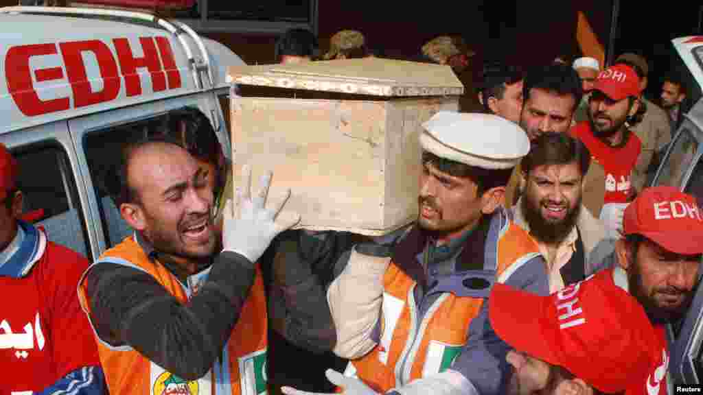 Rescue workers and family members carry the coffin of a student, who was killed during an attack by Taliban gunmen on a school in Peshawar, Pakistan, Dec. 16, 2014.