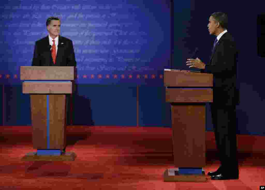 Republican presidential candidate Mitt Romney, left, listens to President Barack Obama during the first presidential debate at the University of Denver.