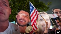 အစ္စရေးလ်နိုင်ငံ၊ တဲလ်အဗီမြို့တော်တွင်လုပ်သည့် ဓားစားခံလွှတ်ပေးရေး တောင်းဆို ဆန္ဒပြပွဲအတွင်း အမေရိကန်အလံနှင့် ဖမ်းဆီးခံ ဓားစာခံပုံများကိုင်လျက် ဆန္ဒပြနေကြသူများ။ (ဖေဖော်ဝါရီ ၄၊​ ၂၀၂၅)​ (AP)