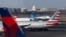 Sebuah pesawat JetBlue mendarat Bandara Nasional Ronald Reagan Washington di Arlington, Virginia, sementara tampak pesawat United Airlines, American Airlines, dan Delta Airlines, 25 Januari 2025. (Foto: Jim Urquhart/Reuters)
