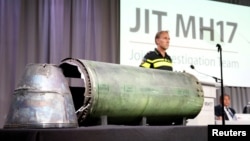FILE - A damaged missile is displayed during a news conference by members of the Joint Investigation Team, who presented interim results in the ongoing investigation of the 2014 MH17 crash in Bunnik, Netherlands, May 24, 2018. 