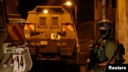 An Israeli soldier stands guard in the West Bank city of Hebron, June 15, 2014. 
