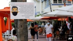 Una señal en la ciudad de Miami Beach informa a los clientes de un hotel sobre cómo protegerse con las máscaras para evitar el contagio en la pandemia de coronavirus.