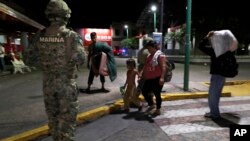 A Mexican marine stands by as camping migrant families are evicted from a park in Tapachula, Mexico, early May 29, 2019. 