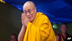 Tibetan spiritual leader the Dalai Lama greets devotees as he arrives to give a religious talk at the Tibetan Children's Village School in Dharmsala, India, May 27, 2015. 